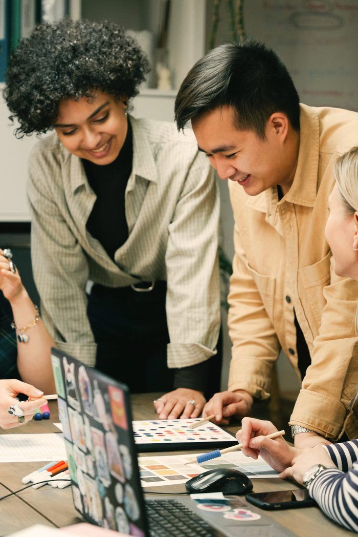 Coworkers laughing at a laptop